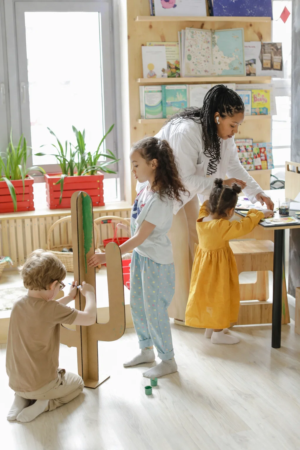 Preschool teacher wearing HYPƐAR custom in-ear monitors for hearing protection in educational environments - Swedish-made 3D-printed custom-fit hearing protection protecting from constant classroom noise while maintaining clear communication with children